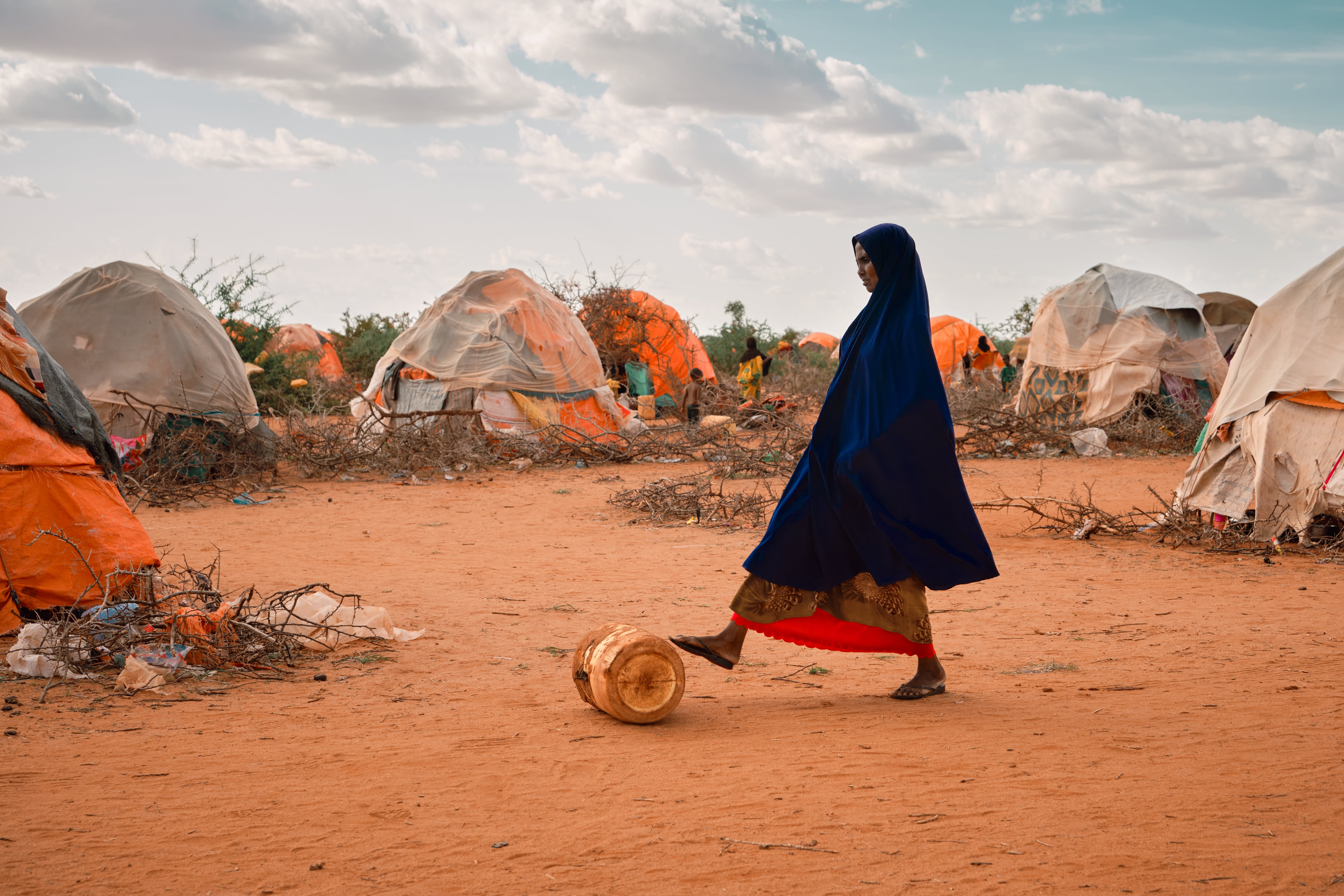 Woman carries a jerrycan with water in a displacement site in Dollow, Somalia. Photo: Claudia Rosel/IOM 2022